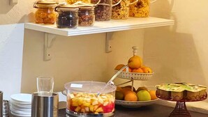 Montaje de bufé con diversos alimentos y una exhibición de frutas.