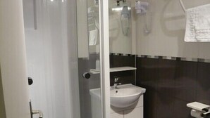 A bathroom with a glass-enclosed shower, a white sink, and a toilet. - Cit'Hotel Saint Jacques  (Blois)