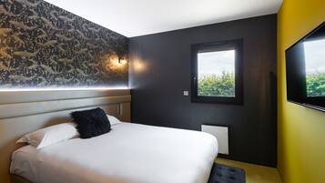 A modern bedroom with a large bed, a black furry pillow, a window with a view, and a wall-mounted TV.
