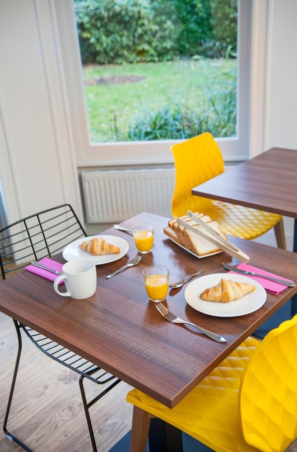 A breakfast table with croissants, orange juice, and a sandwich. - Hôtel Métropole (Boulogne-sur-Mer)