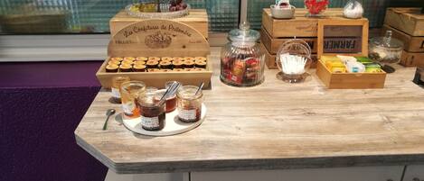 A wooden counter with jars of jam, a tiered fruit display, and various packaged goods.