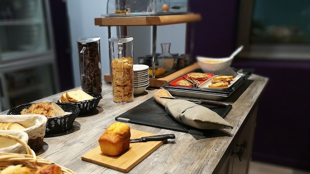 Een ontbijtbuffet met diverse soorten eten en bestek.