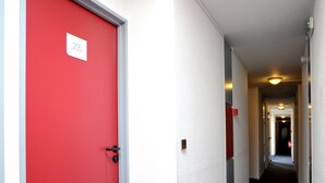 A corridor with a red door labeled "205" and a carpeted floor. - Hotel & Residence Calais Car Ferry (Calais)