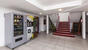 A modern indoor area with a vending machine, a staircase, and a chalkboard menu. - Hotel & Residence Calais Car Ferry (Calais)