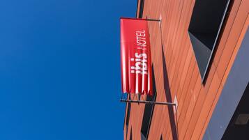 A modern building with red banners hanging from the exterior.