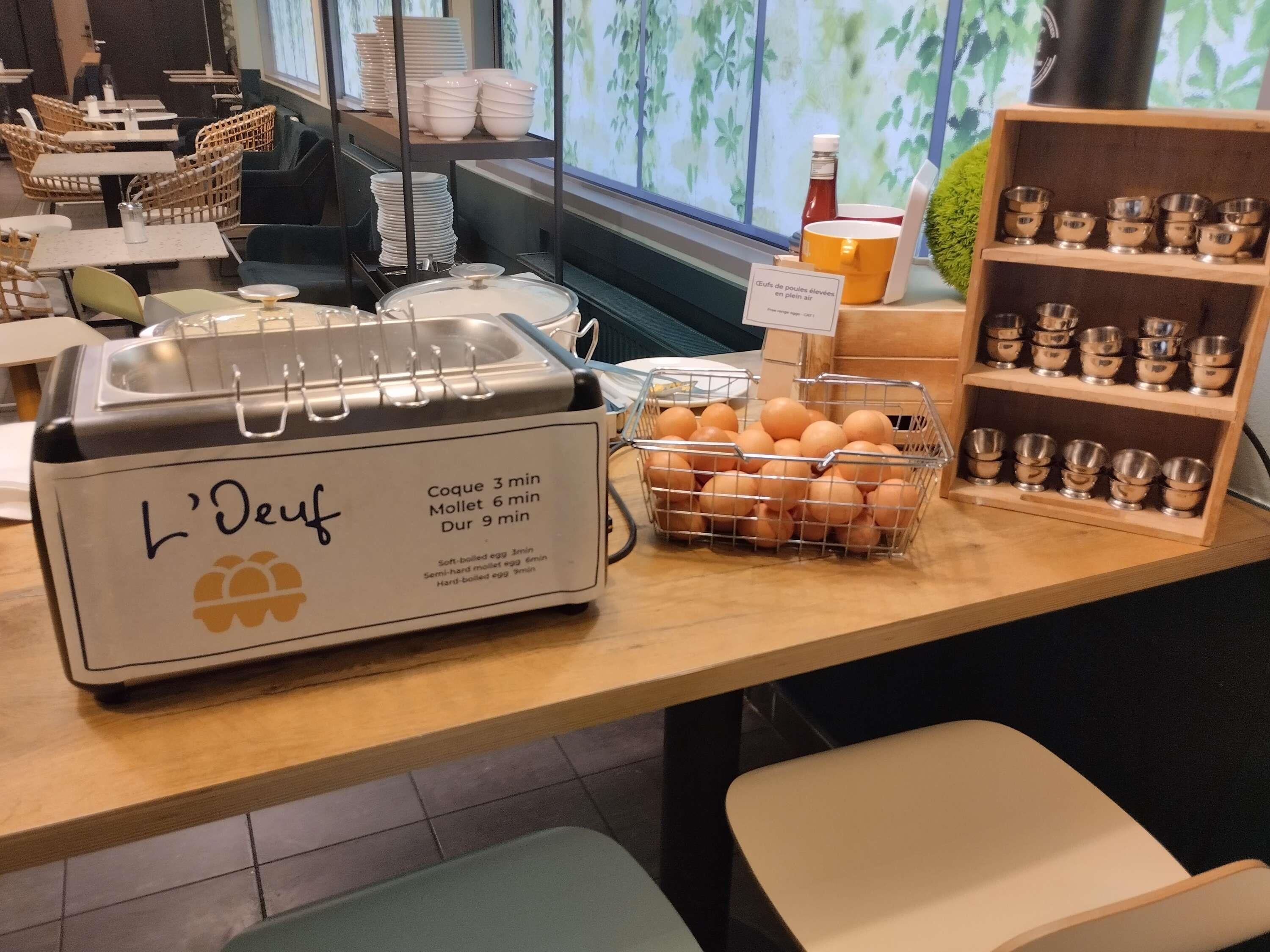 A breakfast station with a sign indicating cooking times for eggs and a basket of eggs.