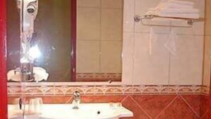A bathroom with a sink, mirror, and bathtub. - Citotel Le Cedre (Noyon)