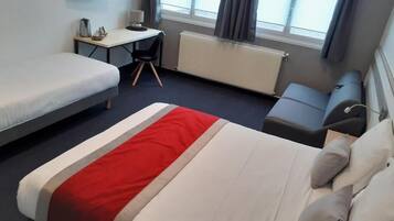 Een hotelkamer met een bed, bureau, stoel en televisie.