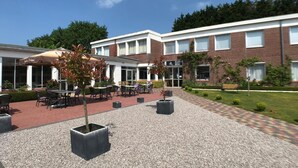 Un hôtel doté d’une terrasse et de jardinières.