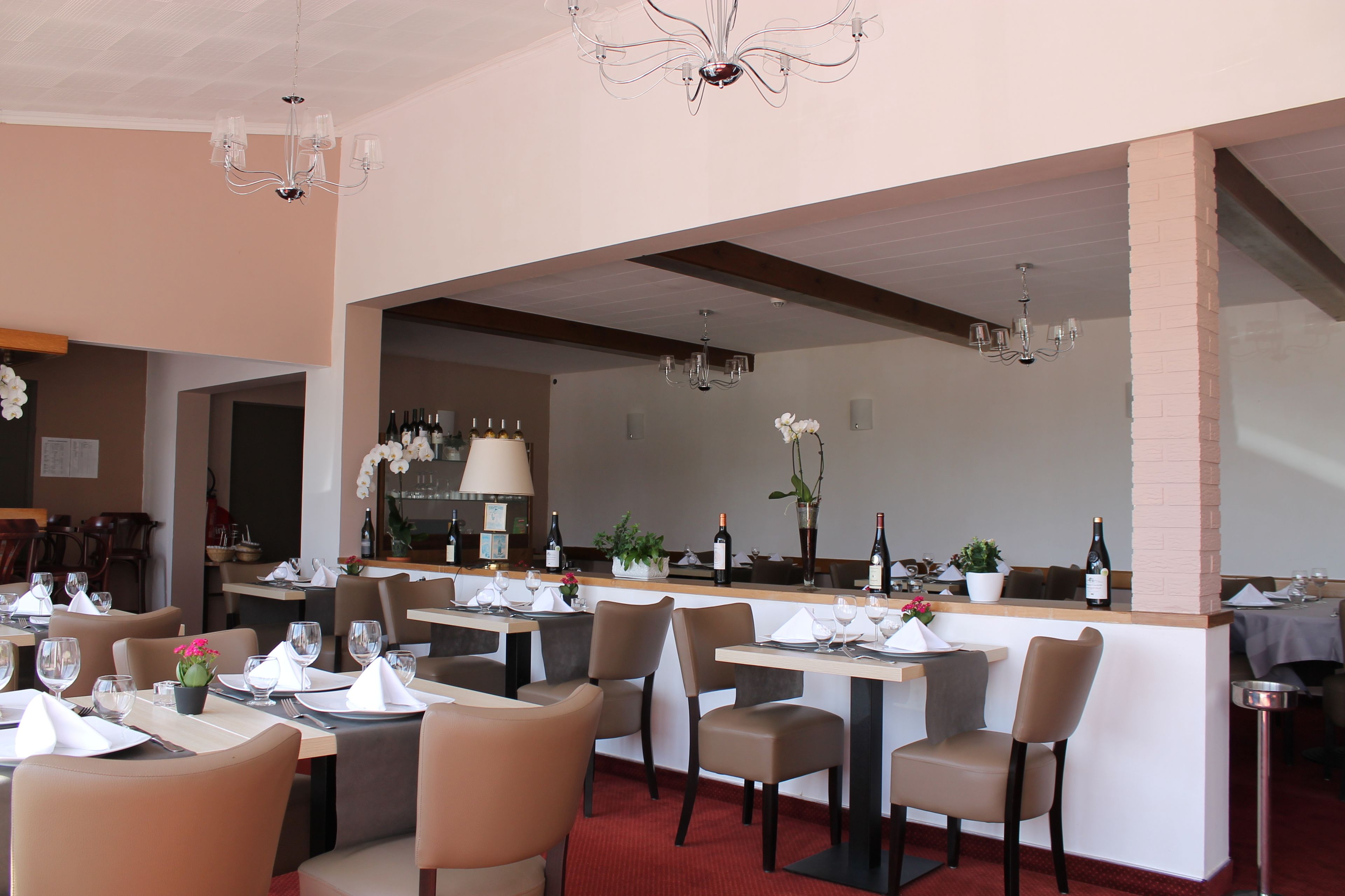 Un ristorante con diversi tavoli, sedie e un'area bar.