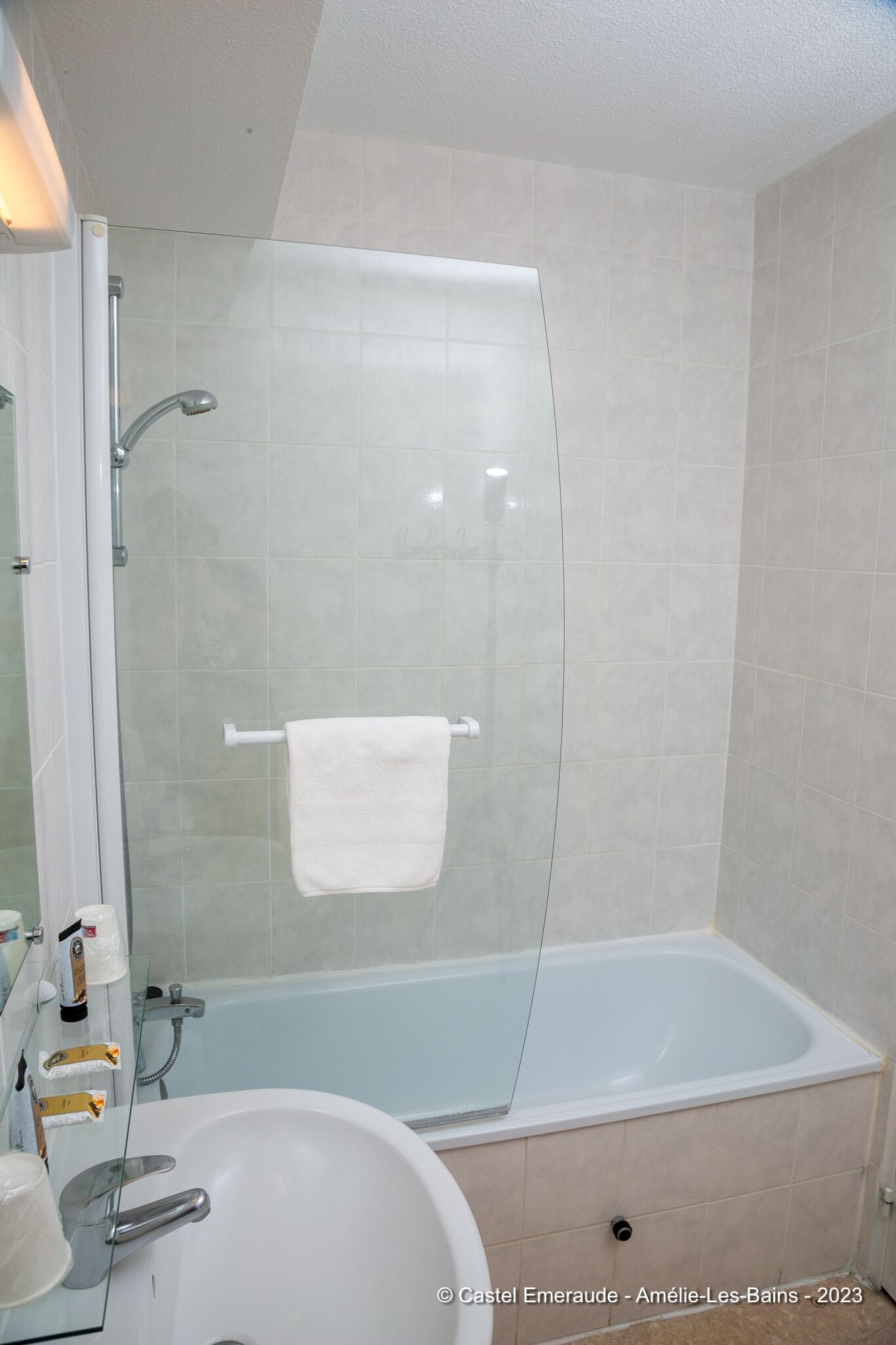 Un baño moderno con ducha de vidrio, una bañera blanca y un lavabo con espejo.