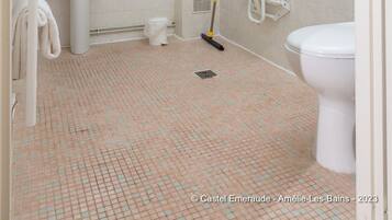 A bathroom with a sink, mirror, towel rack, shower, and toilet.