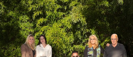 Un grupo de personas en un entorno exterior con césped y árboles.