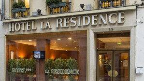 The facade of Hotel La Residence, featuring a classic architectural style with large windows and potted plants on the balconies. - Hôtel La Résidence Lyon (Lyon)