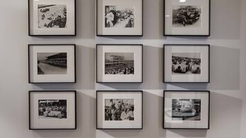 A wall with nine framed black and white photographs arranged in a 3x3 grid.