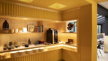 Una cocina moderna con paneles de madera, una cafetera y una variedad de vajilla y utensilios.
