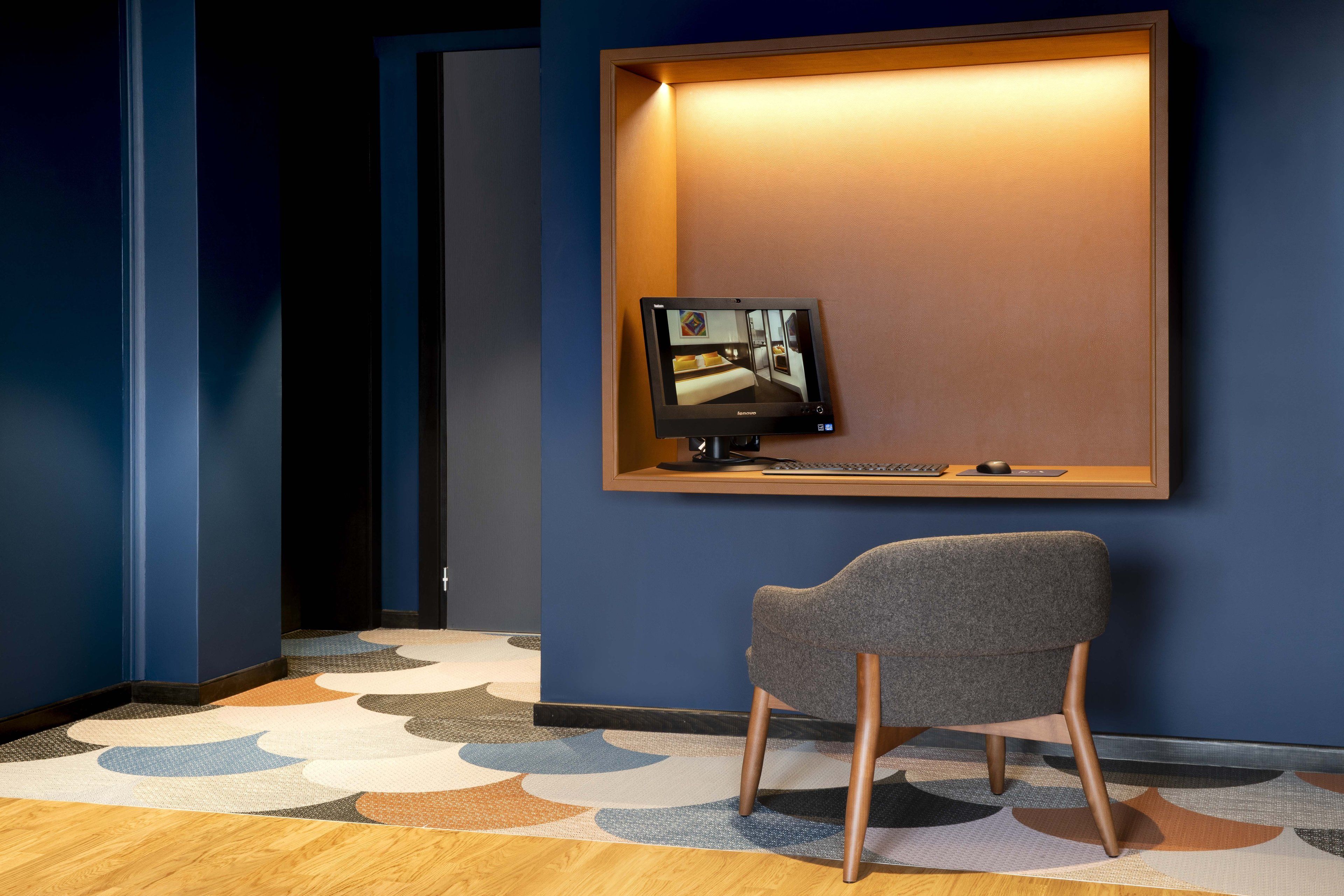 Una habitación de hotel moderna con un escritorio, una silla y una pantalla grande que muestra la vista de la habitación.