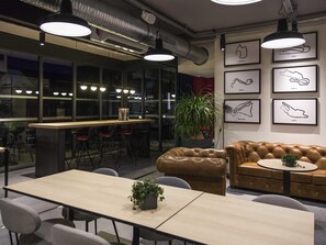 A modern interior with a bar area, seating, and artwork on the walls. - ibis Styles Bâle-Mulhouse Aéroport (Blotzheim)