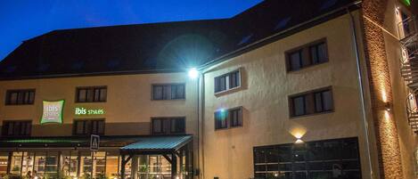 A hotel with a modern design, featuring a covered entrance and multiple windows.