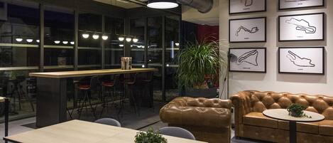 A modern interior with a bar area, seating, and framed artwork on the walls.