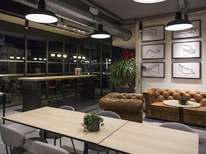 A modern interior with a bar area, seating, and artwork on the walls. - ibis Styles Bâle-Mulhouse Aéroport (Blotzheim)