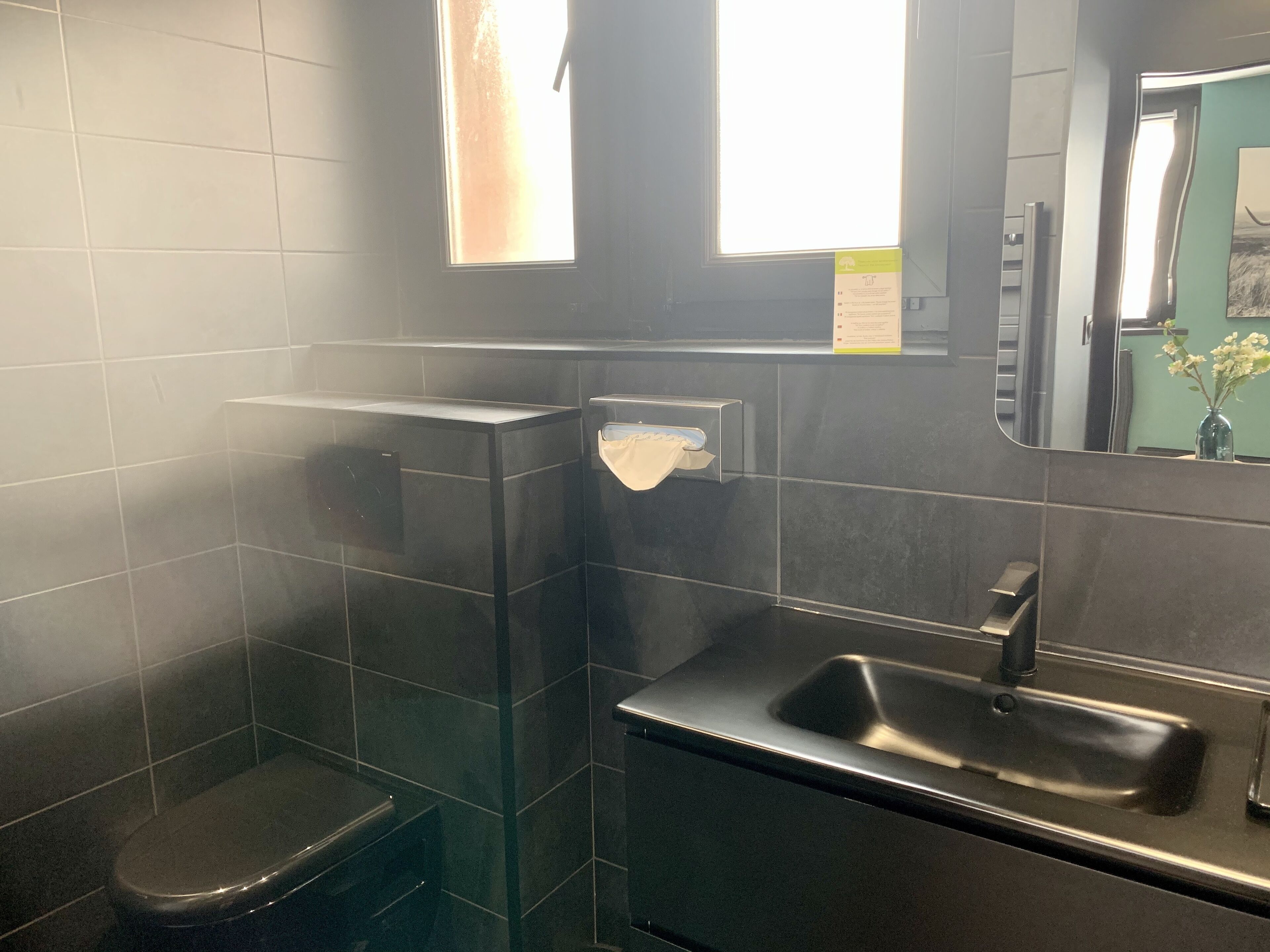 Un baño moderno con inodoro, lavamanos y espejo.