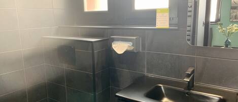 Un baño moderno con inodoro, lavamanos y espejo.