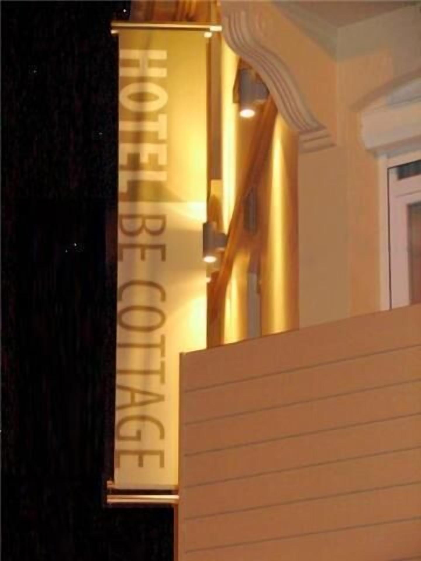 A hotel sign with the text "HOTEL BE COTTAGE".