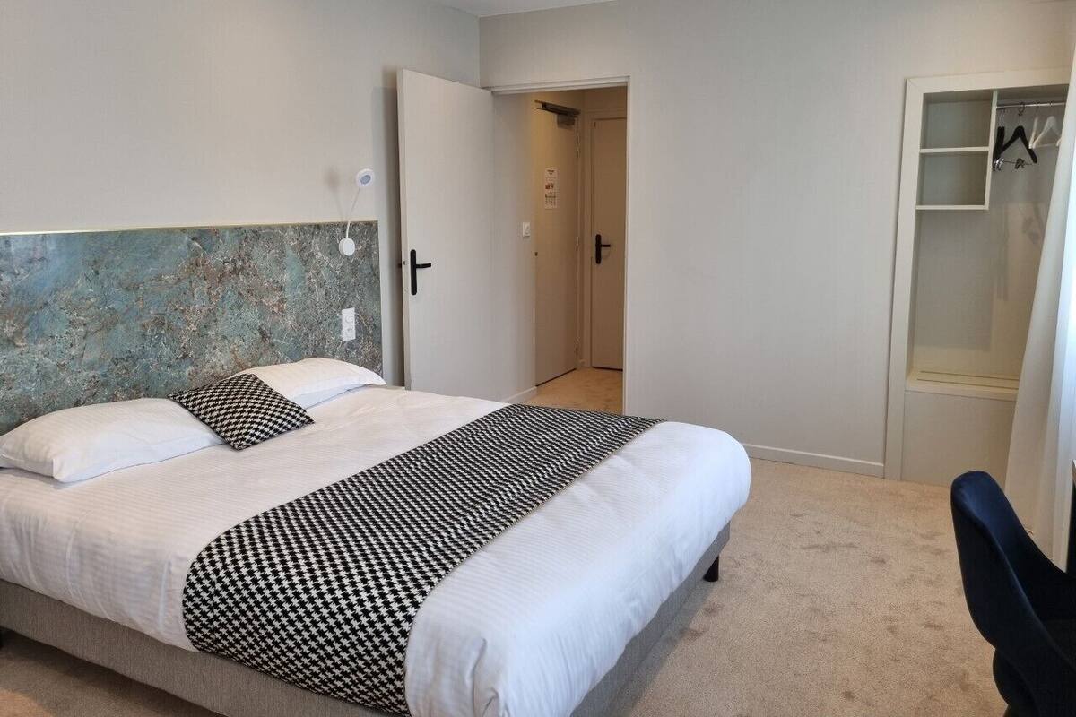 Un dormitorio con cama, armario y puerta que da a otra habitación.