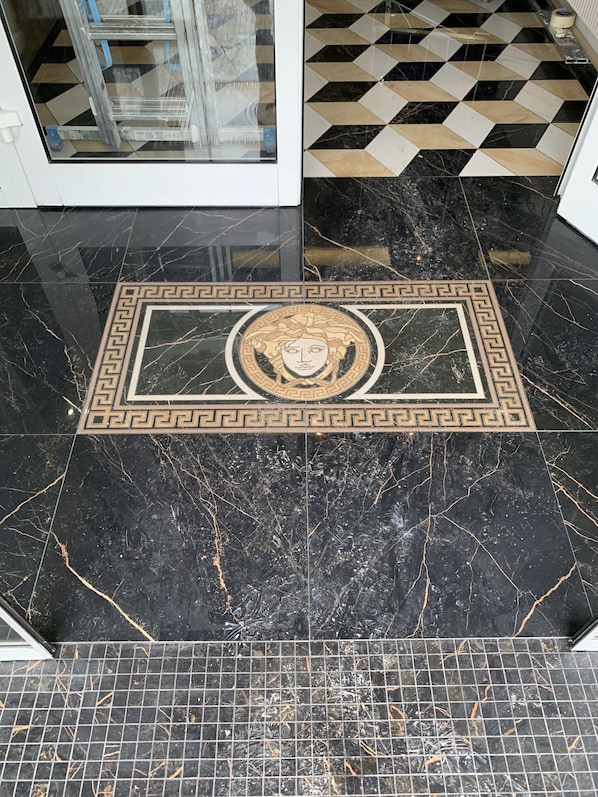 A black marble floor with a decorative border and a central emblem. - Hôtel d’Angleterre Rouen Centre (Rouen)