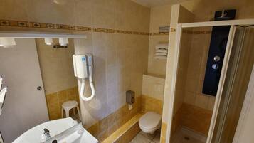 A bathroom with a toilet, sink, and shower area.