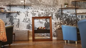 Una sala de estar acogedora con chimenea, un gran mural en la pared y muebles modernos.