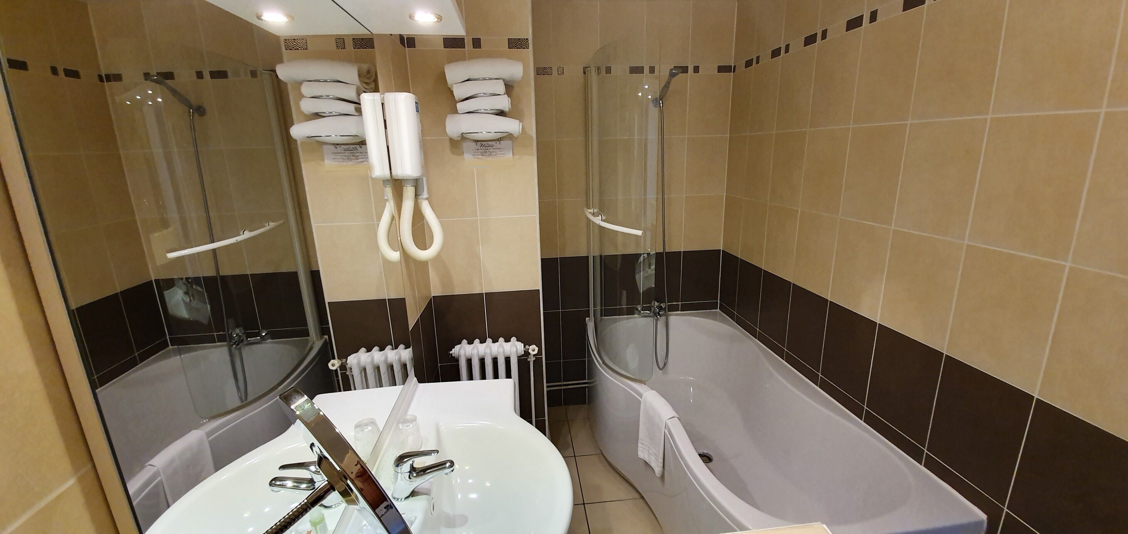 Un bagno moderno con vasca, cabina doccia separata e mobile lavabo.