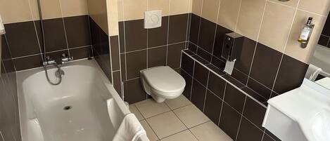 Une salle de bain moderne avec une baignoire, des toilettes et un lavabo.