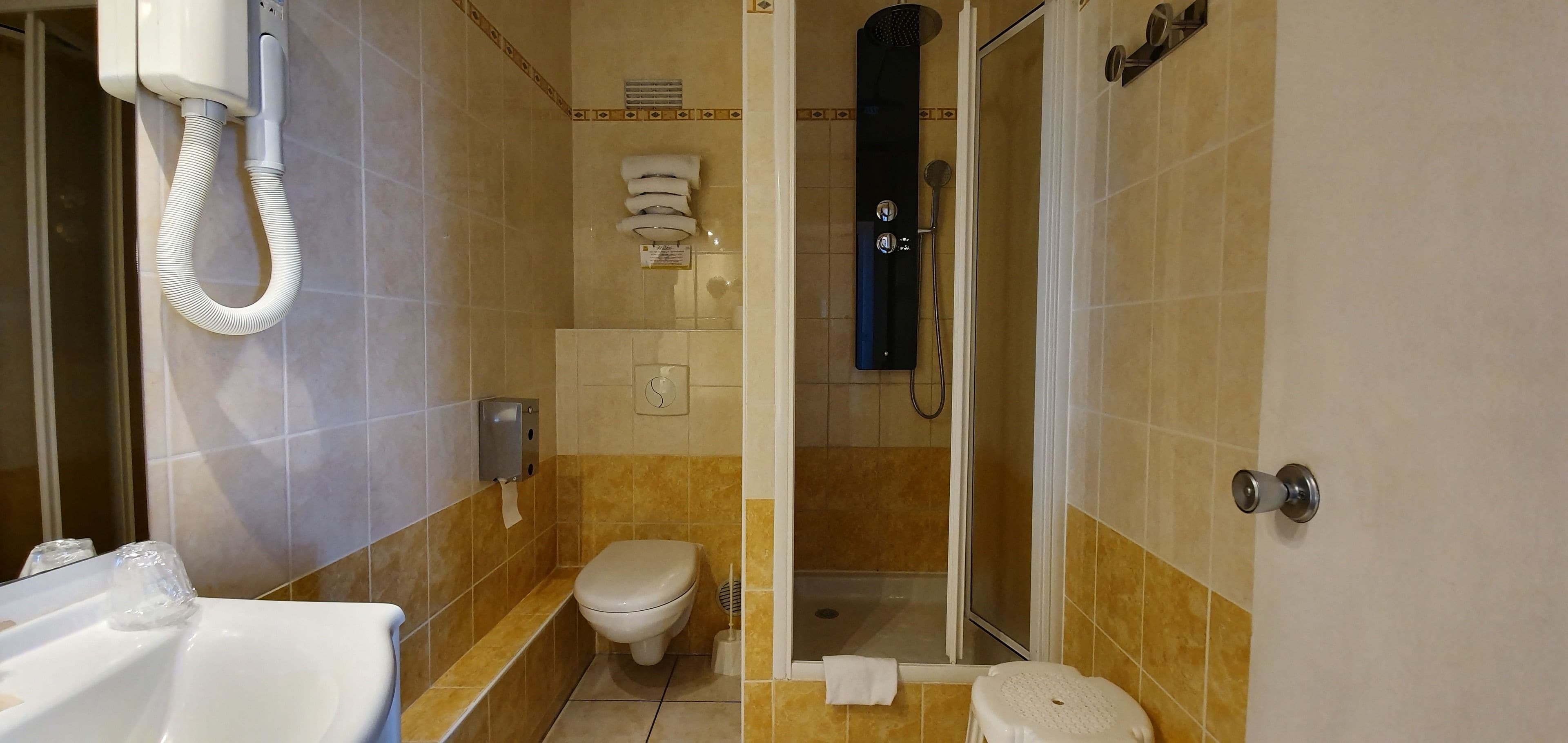 Ein Badezimmer mit Toilette, Waschbecken und Dusche.