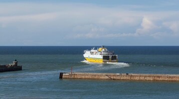 Un ferry navegando por aguas tranquilas, con un cielo despejado al fondo.