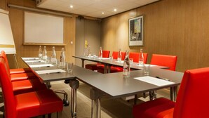 A conference room with a long table, red chairs, water bottles, and a projector screen. - Appia La Fayette (Paris)