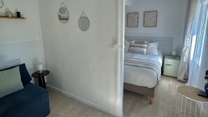 Une chambre à coucher moderne avec un lit, des tables de chevet, une commode et un bureau.
