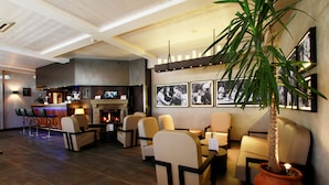 Een moderne lounge met zitplaatsen, een open haard en een bar.