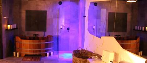 Une salle de bain moderne avec une douche à parois de verre, des baignoires en bois et un grand miroir.