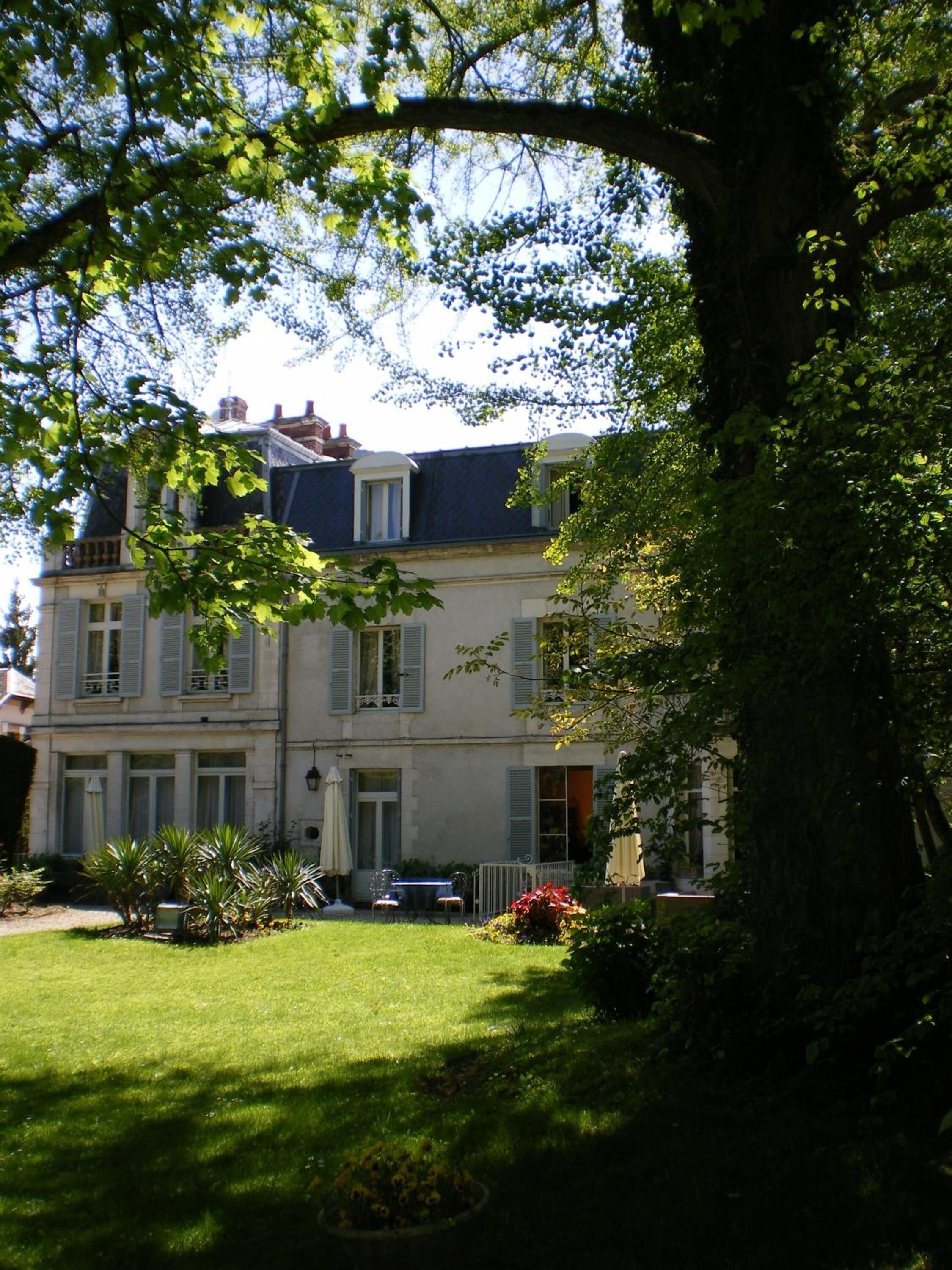 A two-story building with a garden in front.