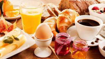 A breakfast setting with croissants, pastries, eggs, and various spreads.