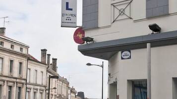 A hotel with a prominent sign, a bus stop, and a street with buildings.