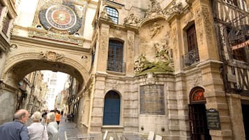 An ornate building with a large clock, a blue door, and a sign for a coffee shop.