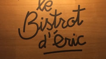 A wooden sign with the text "le Bistrot d'Éric" and a decorative border.