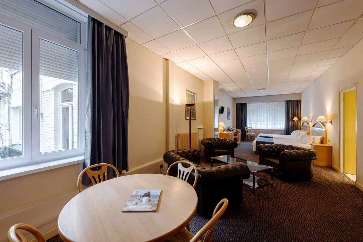 Ett hotellrum med en matplats, en säng och ett badrum.