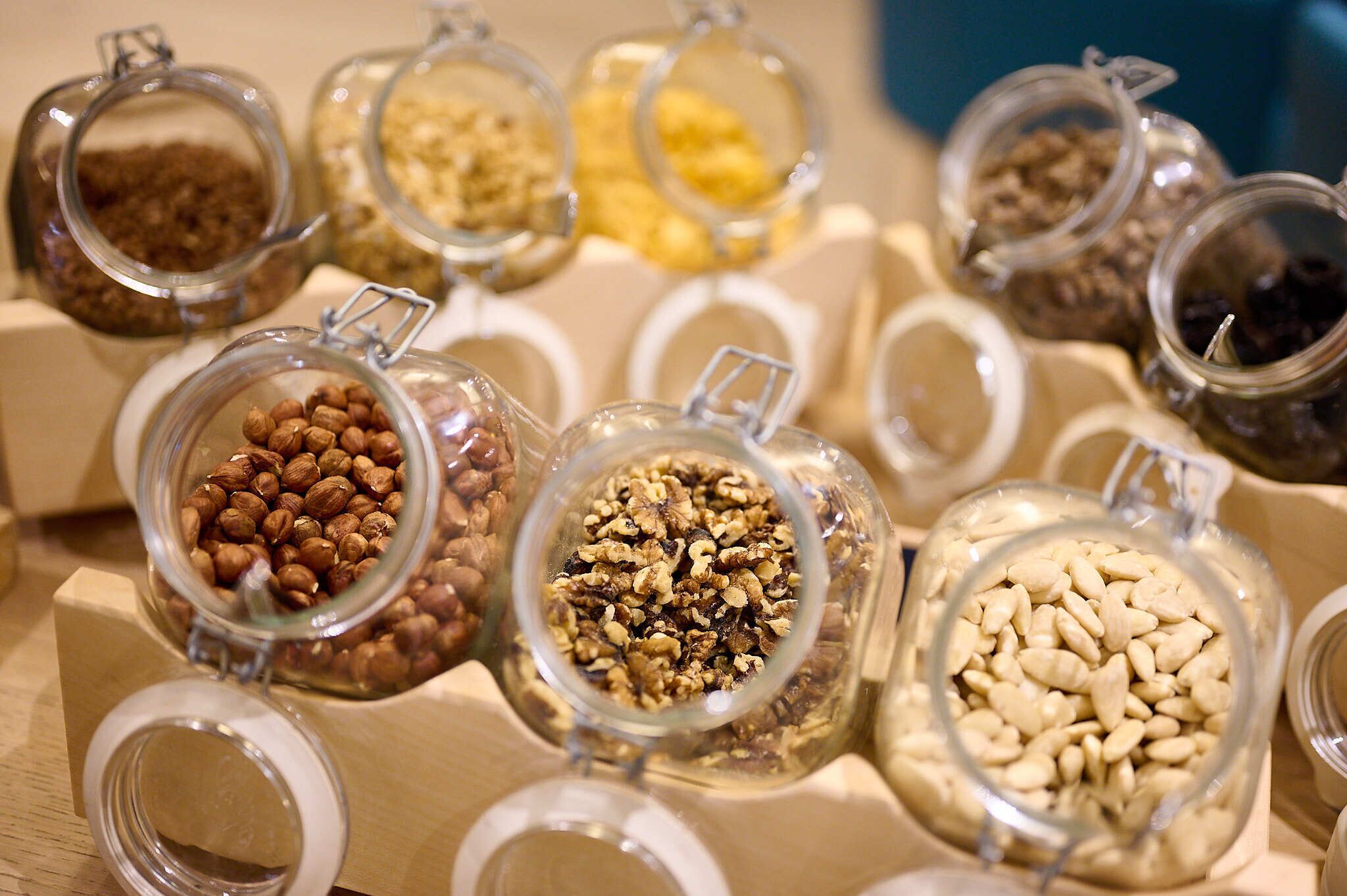 A display of various nuts and seeds in glass jars.