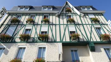 Un immeuble à plusieurs étages, de style architectural européen traditionnel, caractérisé par une structure en bois et de nombreuses fenêtres ornées de jardinières.