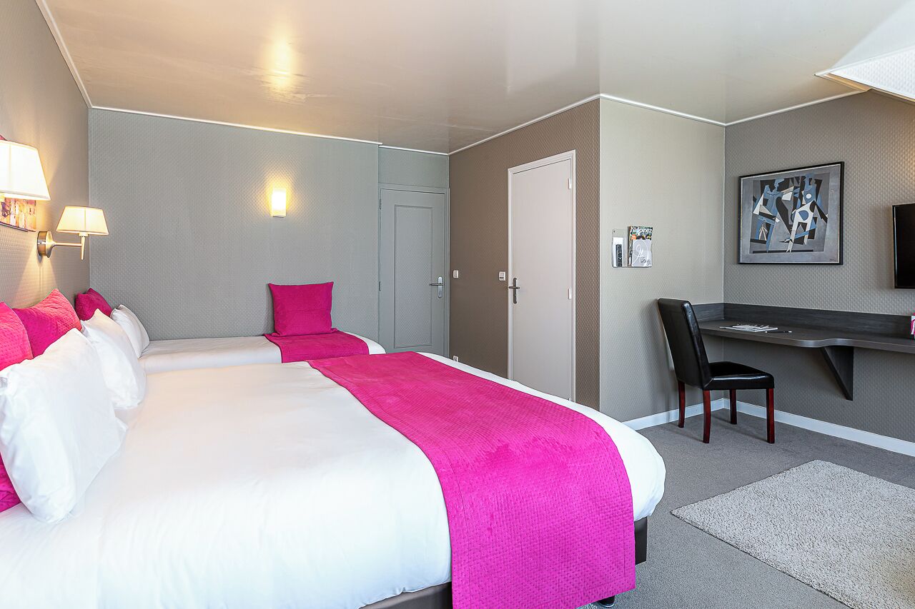 Una habitación de hotel con una cama grande, un escritorio y una silla.