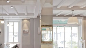 A modern interior with a wooden ceiling, a glass door leading outside, and a table with a laptop. - Hôtel des Dunes (La Baule-Escoublac)